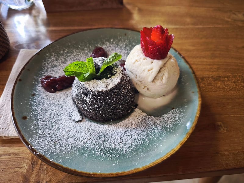 A chocolate lava cake with ice cream and a strawberry at Cafe Lilu