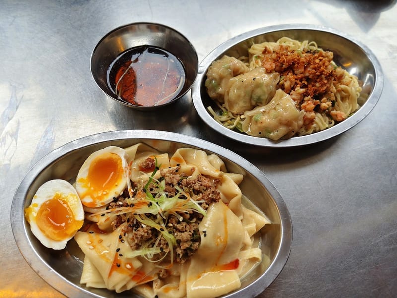 Hand-pulled noodles with a soft egg and pork, with dipping sauces at Double Dragon Temple