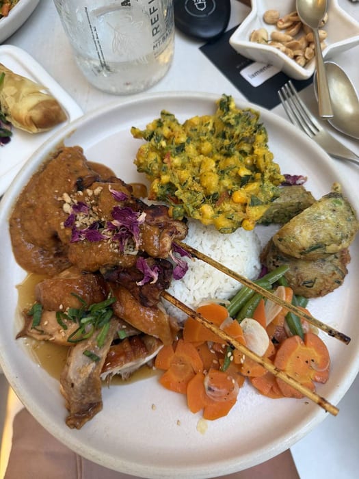 A plate of chicken, rice, corn fritters and vegetables at This Is Bali