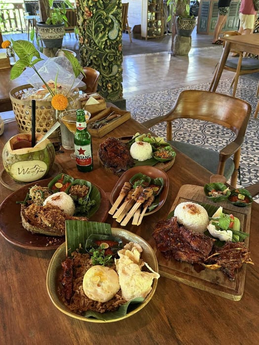 A table of Balinese dishes with rice, satay and a Bintang beer at Wedja Restaurant