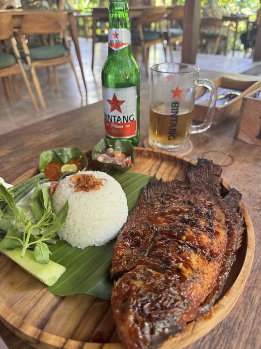 Grilled whole fish with rice on a banana leaf at Wedja Restaurant