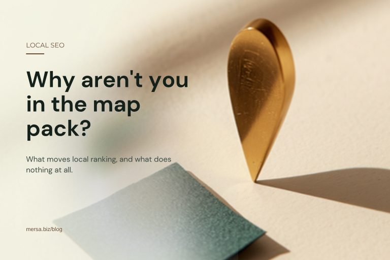 A brass teardrop map-pin marker standing on a cream surface beside a folded square of dark green cloth, captioned "Why aren't you in the map pack?".
